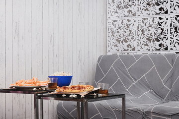 Comfortable couch with foods and drinks on table indoors. Home cinema. 