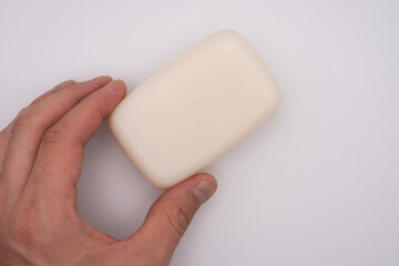 holding a white soap with white background with copy space