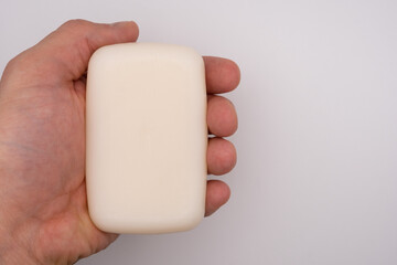 holding a white soap with white background with copy space