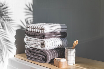 Bath spa soap towels pile soft textile cotton washcloth on wooden tabletop at sunny bathroom...