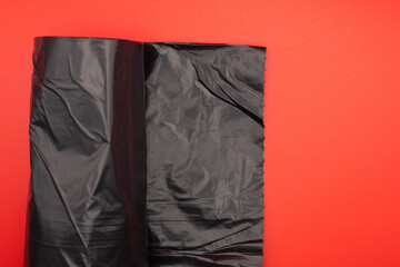 Black polyethylene plastic garbage bag with red bottom and copy space