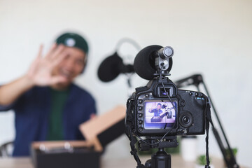 Potrait of excited content creator recording vlog shooting in home studio review product and giving...