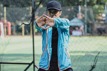 Sportsman  stretching hands in public park in the morning. 