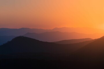 Fototapeta premium Silhouette view of the peaks of mountain range under colorful dusk sky at sunset