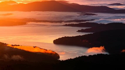 Fototapeta premium Aerial view of the fog over the rocky cost at sunset