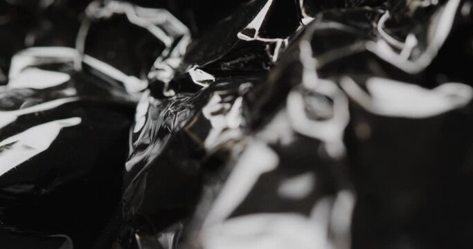 Close up of black crumpled plastic rubbish bag in slow motion