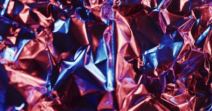 Close up of blue and red crumpled pieces of plastic material in slow motion
