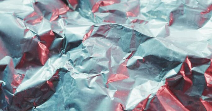 Close up of gray crumpled pieces of plastic material in slow motion