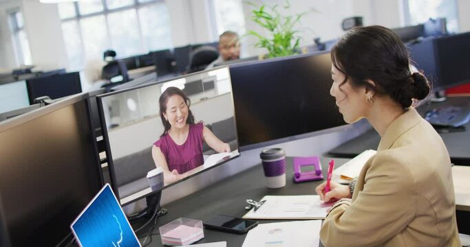 Asian businesswomen having video call and using laptop with digital chat on screen in office