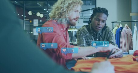 Animation of social media icons floating over two diverse male photographers discussing at studio