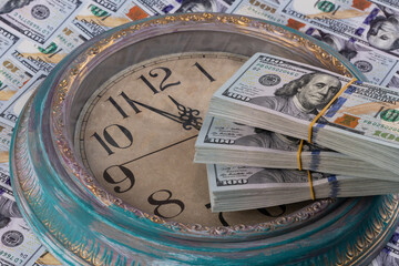 Fototapeta na wymiar 100 American dollar bills and the dial of a large wall clock