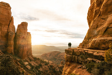Young couple stand in amazement on top of Cathedral Rock in Sedona.