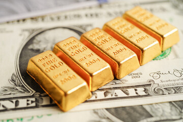 Gold bars on US dollar banknote money, finance trading investment business currency concept.