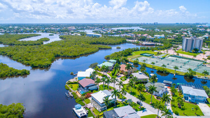 Aerial View from a Drone in Florida Real Estate Featuring Manicured Landscaping with Blue Bay...