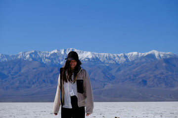 Fototapeta premium woman standing in salt field in front of mountains