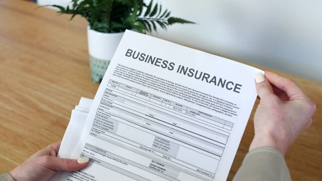 A woman opening a business insurance policy document.