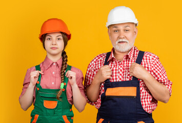 teen girl and granddad builder in helmet on yellow background