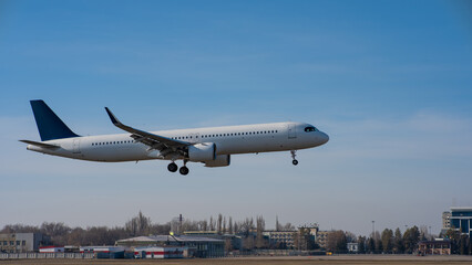 Ground view of a landing plane against a blue sky. 