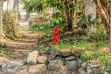 Red fire hydrant beside dirt path in nature park.