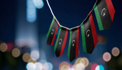 A garland of Libya national flags on an abstract blurred background - obrazy, fototapety, plakaty