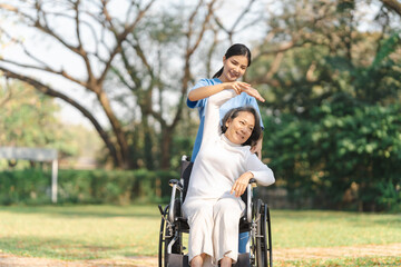 Young asian care helper with asia elderly woman on wheelchair relax together park outdoors to help and encourage and rest your mind with green nature. physical therapy