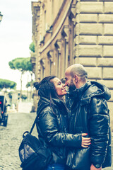 Fototapeta na wymiar Portrait of Happy Tourists couple in love traveling at Rome, Italy, Hugging at Campidoglio Square.Concept of Italian travel. 