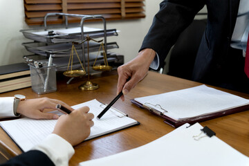 Law firms discussing with pen pointing at documents