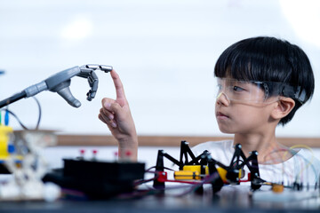 Asian boy is touching his finger The robot model being tested © sabthai