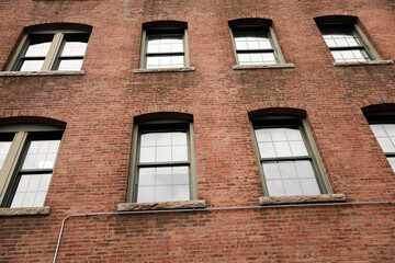 A multi-story brick building featuring a mix of commercial offices and residential apartments, with classic architectural details and large windows.