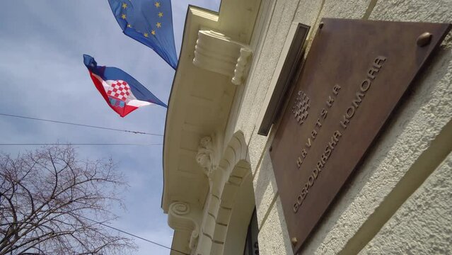 Croation flag and the flag of Europian Union against blue sky in on the state chamber building Zagreb, Croatia