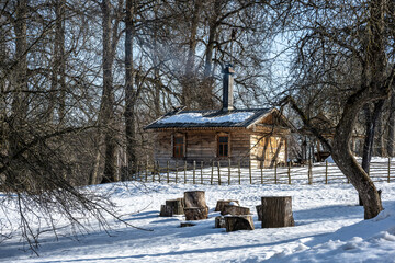 rural landscape with a frozen lake and a forest and a house on a sunny winter day in the suburbs of Veliky Novgorod