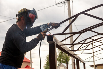 A worker welds metal at a construction site.