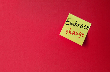 Embrace change symbol. Orange steaky note with concept words Embrace change. Beautiful red background. Business and Embrace change concept. Copy space