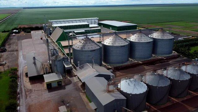 Drone flight over an industrial seed and grain company with huge silos for the storage of the products.