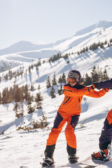 Pair of snowboarders skiing from the top of the mountain on snowboards