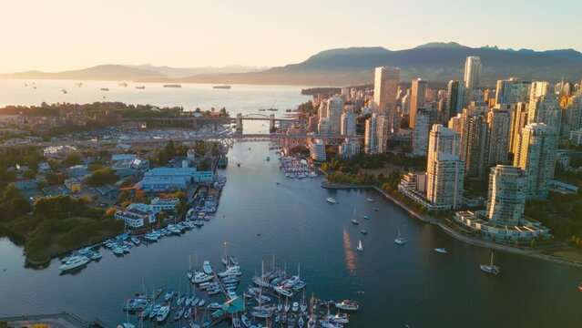 Vancouver downtown skyline aerial crane down shot over marina, BC, Canada at sunset