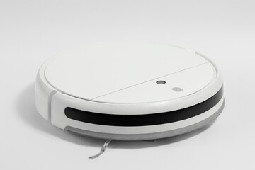 White robot vacuum cleaner with a brush on a white background.