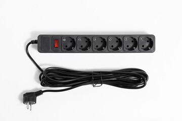 Black extension cord with red power on off button on white background, top view.