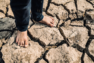 Asian girl sitting sadly in a dry area concept of drought and lack of water