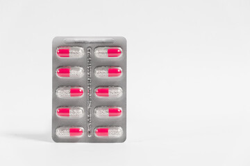 Blister with red pills on white background.