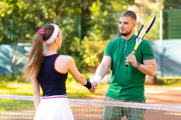 Obraz premium couple tennis players playing on court. end of match. man and girl handshaking after match. daylight saving time family. healthy lifestyle, amateur sports, unusual date