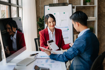 Two business workers talking on the smartphone and using laptop at the office..