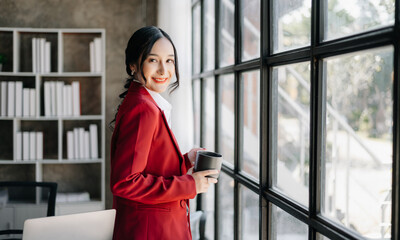 Young attractive Asian female office worker business suits smiling at camera in office