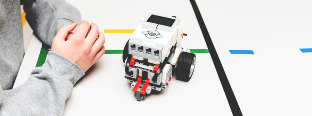 Teen girl student with diy robot on stem education class.Teen scientist working on new project.Stem education Learning To Program Robot Vehicle.Banner. © ARVD73