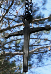 wooden cross hanging on tree in forest
