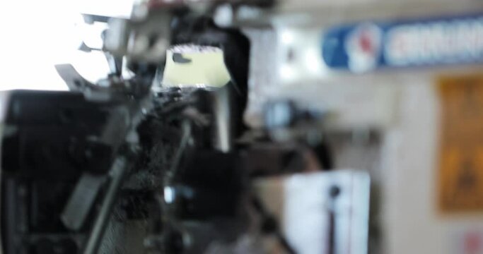 working mechanisms of an overlock sewing machine. macro. automatic sewing machine in operation. overlock details in motion