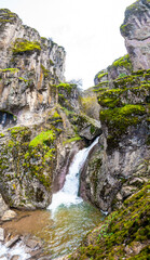 Fototapeta na wymiar Waterfall cascade on mountain rocks.