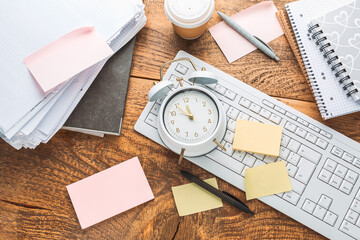 Time management concept. Composition with alarm clock on wooden table with laptop computer,...