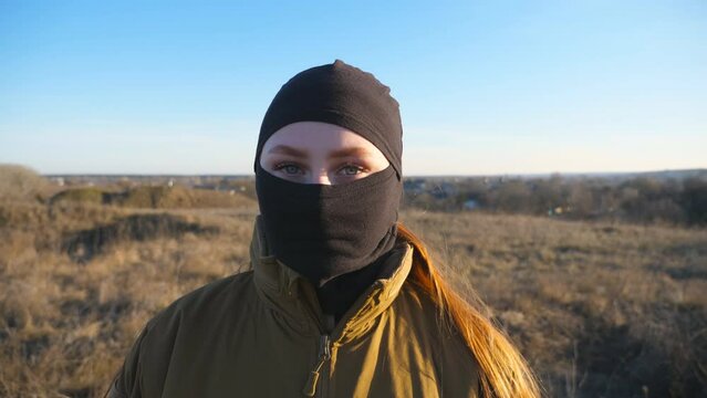 Portrait of female ukrainian soldier looking at camera. Serious sight of woman in military camouflage uniform during war. Victory against russian aggression. Invasion resistance concept. Close up