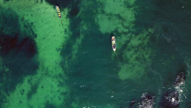 Top-down shot of boats floating in the tropical waters in Pejerrey beach, Chile
